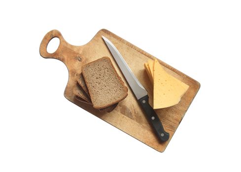 Bread, cheese and knife lying on breadboard. Isolated on white with clipping path