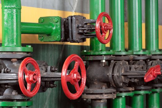 Industry background with green pipes and red valves