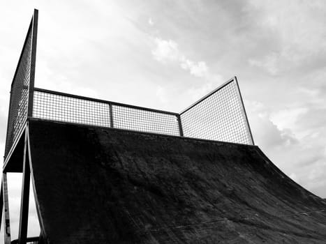 Grunge skate ramp seen from skater's point of view, over blue sky - with copy space