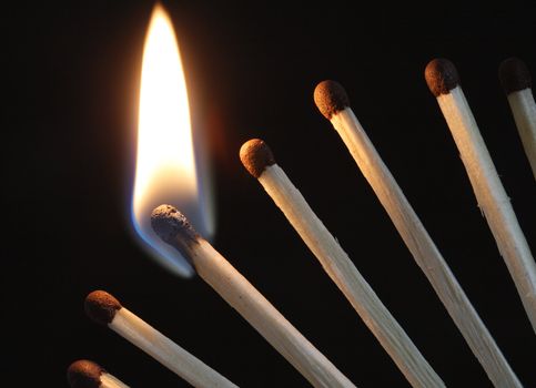 Closeup of few burning matches on dark background with copy space