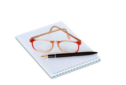 Spectacles and fountain pen lying on spiral notebook. Isolated on white with clipping path