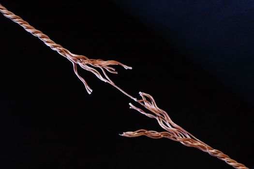 Frayed rope about to break isolated on black background with copy space