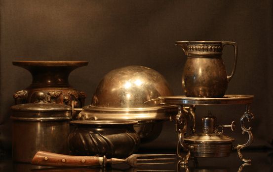 Collection of various bronze vintage dishware on brown background
