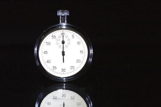 Closeup of old stopwatch isolated on black background with copy space
