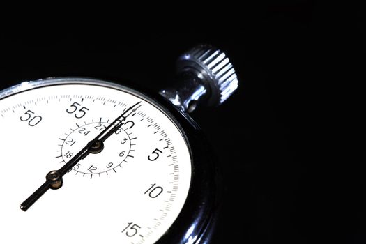 Closeup of old stopwatch isolated on black background with copy space