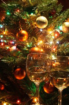 Closeup of two wineglasses standing on background with christmas tree