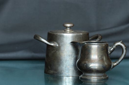 Antique bronze milk jug and sugar bowl isolated on dark background