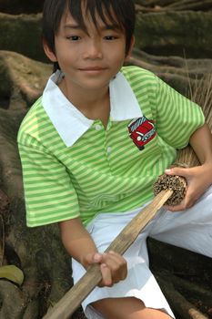 photograph of little asian boy sit down in park