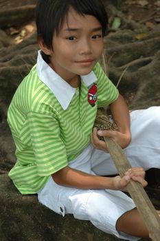 photograph of little asian boy sit down in park