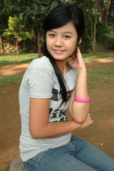 young asian lady sit down in park