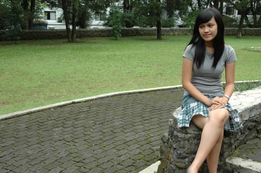 young asian lady sit down in park