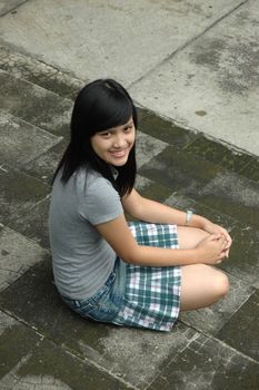 young asian lady sit down in park