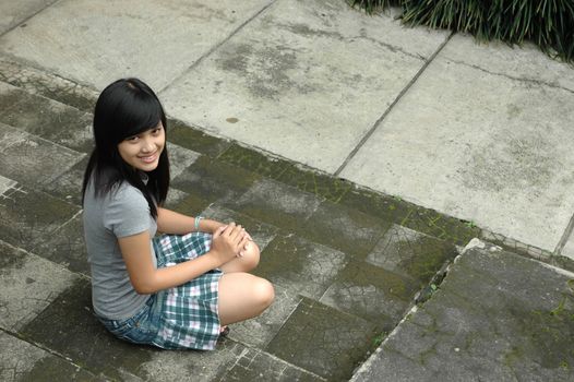 young asian lady sit down in park