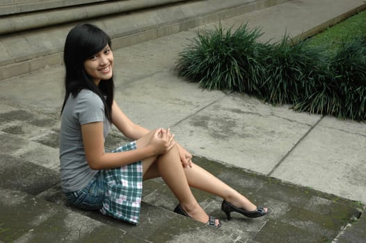 young asian lady sit down in park