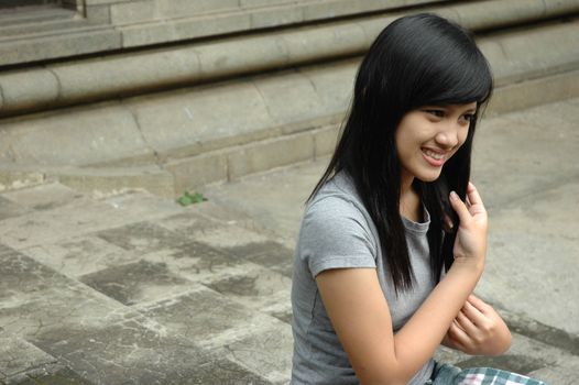 young asian lady sit down in park