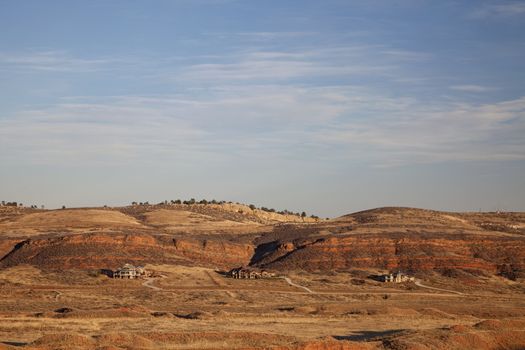 Colorado luxury houses at foothills of Rocky Mountains near Loveland, red sandstone cliffs, fall scenery at sunset with dry vegetation