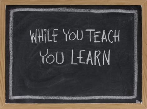 while you teach, you learn - white chalk handwriting on blackboard