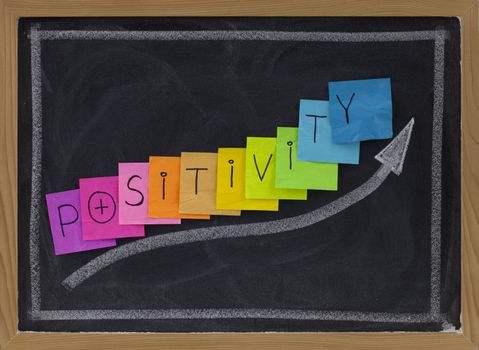 positivity concept on blackboard - color sticky notes and white chalk drawing