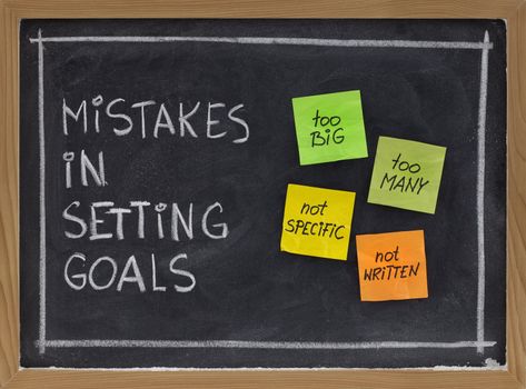 common mistakes in setting goals (too many, too big, not specific, not written) - concept presented with sticky notes and white chalk handwriting on blackboard