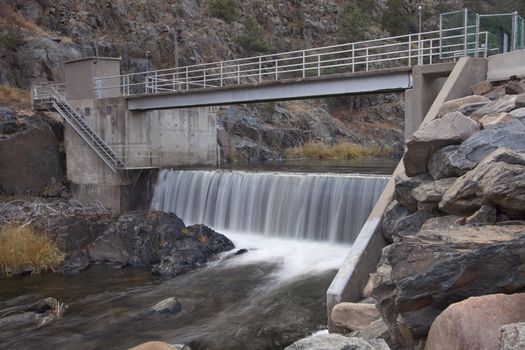 Deep and dark canyon of Big Thompson River with a small dam diverting water for farmland irrigation, Rocky Mountains, Colorado.