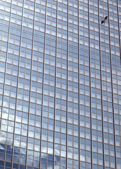 Window cleaner man climbing a skyscraper facade