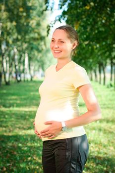 Beautiful pregnant woman relaxing in the park