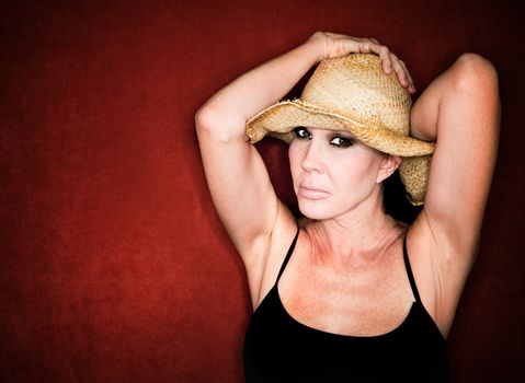 Beautiful woman holding onto her strwa cowboy hat