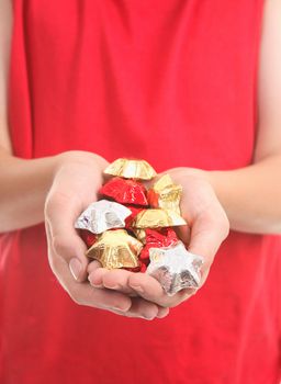 Cupped hands hold a handful of  foil wrapped chocolate stars.