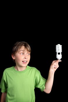 A boy holds an energy efficient compact fluorescent light bulb with space for your text or message. vertical.