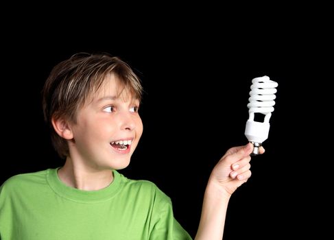 Horizontal closeup of a boy holding an energy efficient light globe and smiling inspirationally.