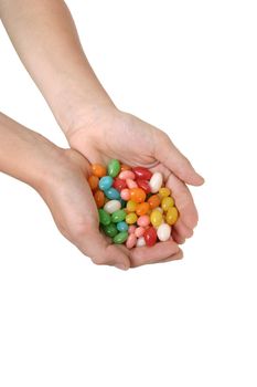 A child holds a handful of coloured lollies / candy.

