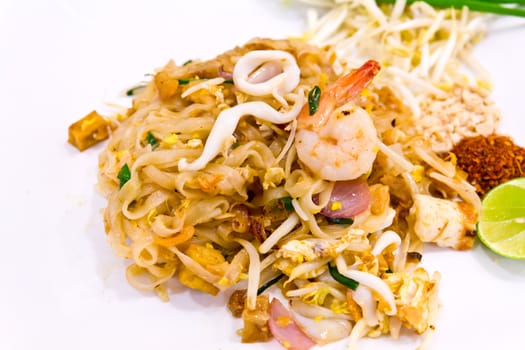 Seafood pad Thai dish of fried rice noodles on a white plate