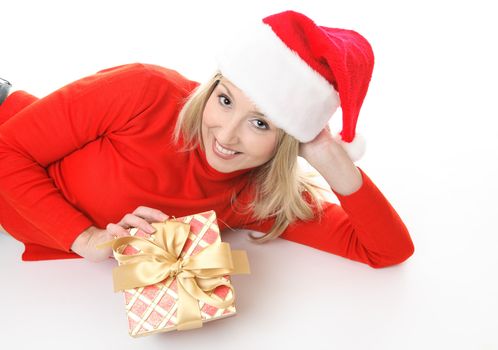 Smiling girl lying on the floor casually and holding a Christmas present.