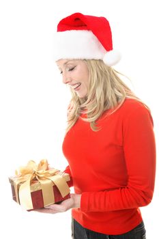 A smiling woman receiving a Christmas gift.   She is looking down and smiling in appreciation.