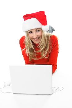 A girl using a laptop computer is browsing the internet and shopping online for gifts.  She is looking up and smiling