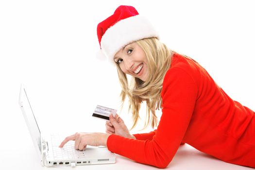 Shopping online is easy, convenient and secure.  Smiling female using a laptop and holding a credit card or other card to buy Christmas gifts, pay bills or  banking.  All data on back of  card has been replaced with made up info.   This is not a real card but is made to look like one..  