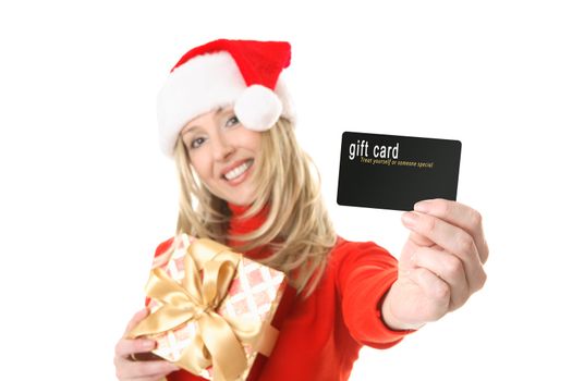 A woman holding a gift and outstretched arm showing a gift card, credit card or other card or object.  Focus is the hand and card.  Change the card or text to suit your needs.