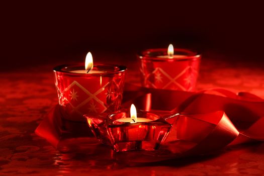 Votive candles on dark red background