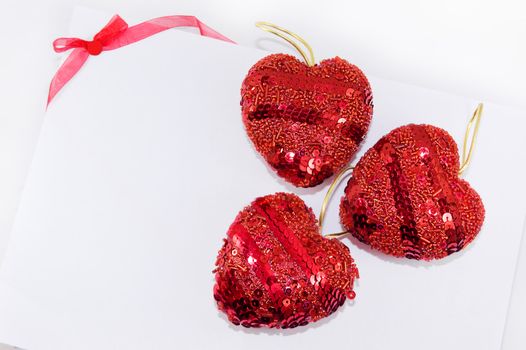 Red hearts and ribbon on white background, may be used as celebration card