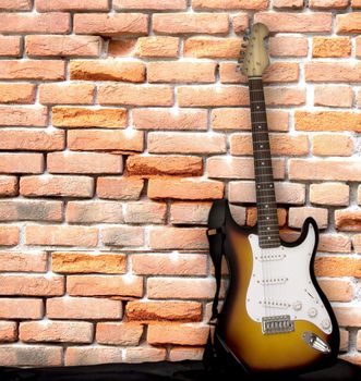 Electric guitar leaning over a brick wall