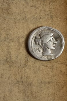 Silver AR denarius from Roman Republic dated 89bc on aged paper.  Front side depicting female draped hair taken in chignon.  Behind the nape of the neck, ROMA, Under the neck, M.Cato. Issuance of coinage was administered by annuallly elected magistrates (moneyers) and coins usually bear their names.  Space for text.