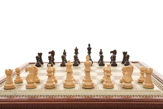 A carved marble chess board and wooden chess pieces.  Focus to foreground.