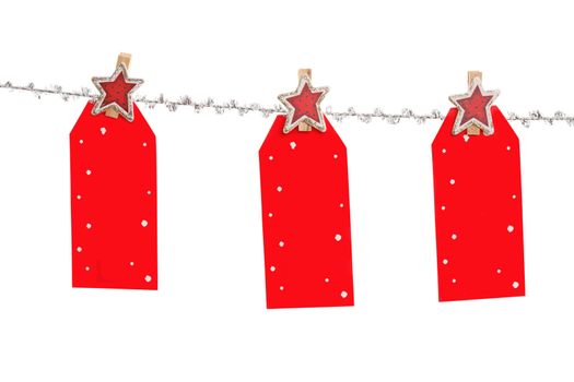 Three Christmas tag hang from silver line.  , blank with space for your own message.