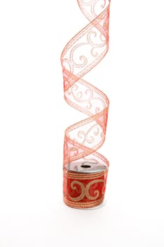 Curling red gauze ribbon decorated with gold glitterr swirls.   For wrapping and decorating  presents and gifts.