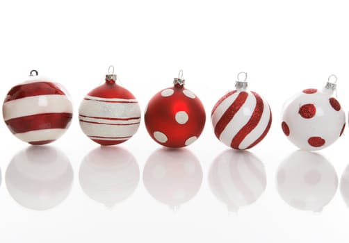 Red and white Christmas baubles with various designs on a white background.