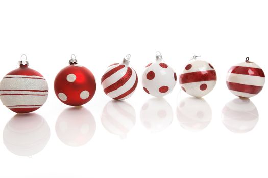 Red and white Christmas baubles on a white background with space for copy.