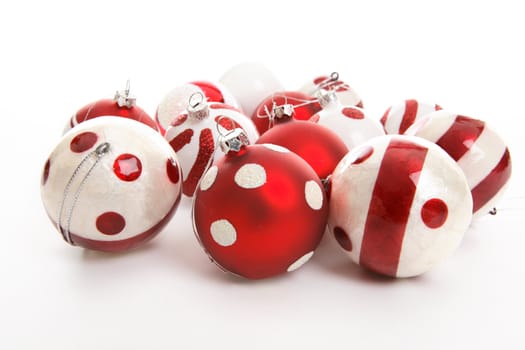 Christmas decorations sitting on a white background.  Focus to foreground balls.