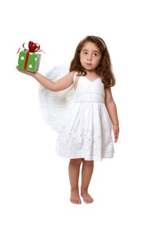 Little girl in feathered angel wings and white dress holds a present or gift
