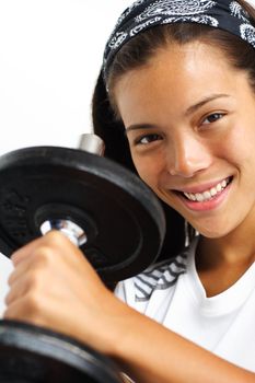 Attractive woman lifting weights and smiling at the camera. Closeup.