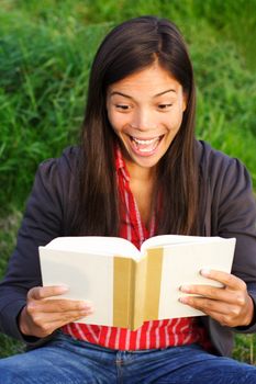 woman surprised by the story she is reading in the book